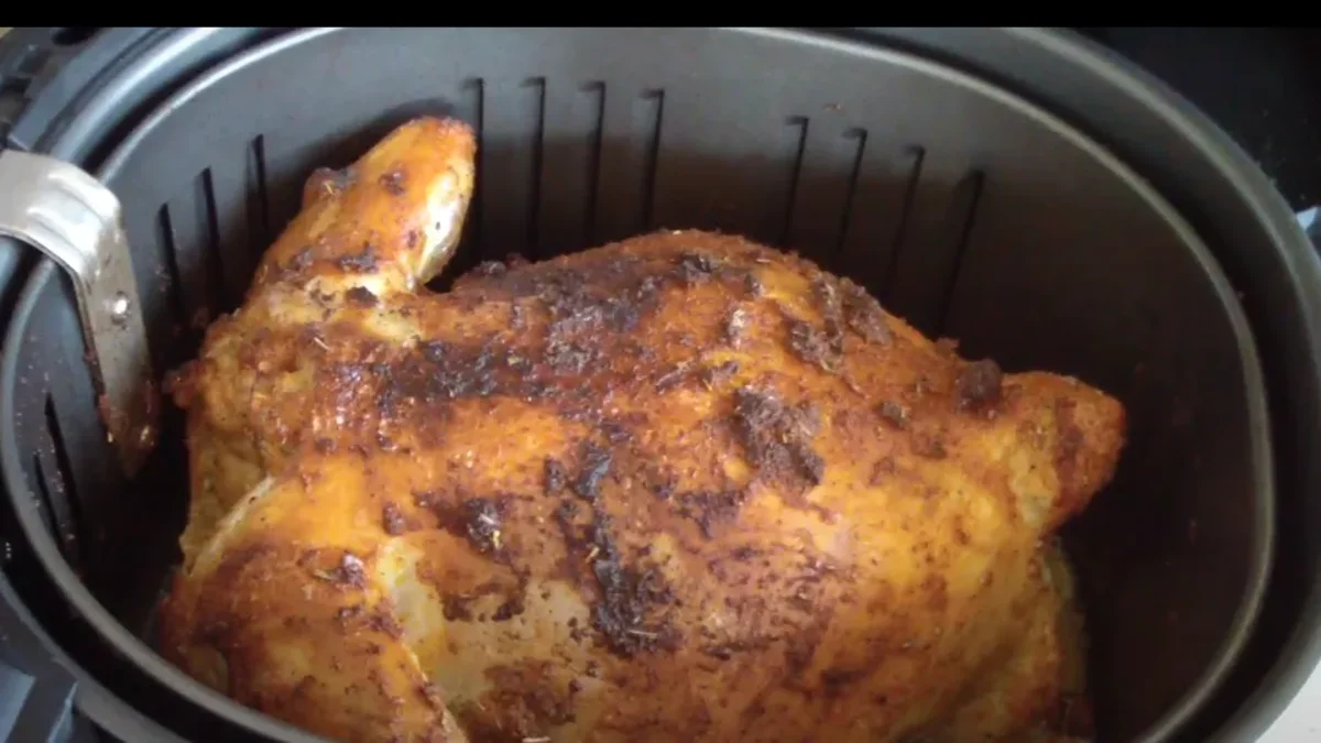 Whole Chicken air fryer Perfectly roasted whole bird cooked in the air fryer, with crispy golden skin and juicy meat, served on a platter with fresh herbs.